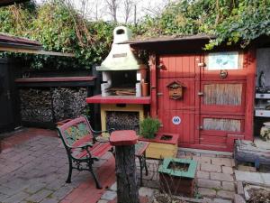 a red house with a stove and a table and a bench at Gesamtes Haus mit Garten - 100% Privatsphäre in Vienna