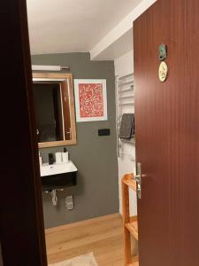 a bathroom with a sink and a wooden door at Gesamtes Haus mit Garten - 100% Privatsphäre in Vienna