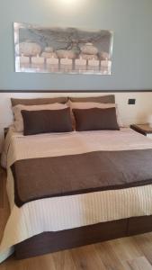 uma cama grande com duas almofadas num quarto em Bed and Breakfast Sanmichele em Druogno