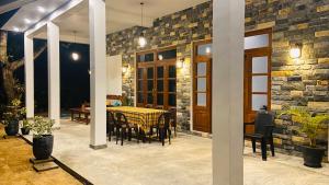 a dining room with a table and a stone wall at Simplex Sea Place in Tangalle