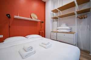Un dormitorio con una cama blanca con toallas. en Parisuites Central Canal Saint Martin Design & Luxe & Cosy, en París