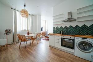 a kitchen with a table and a washing machine at Parisuites Central Canal Saint Martin Design & Luxe & Cosy in Paris