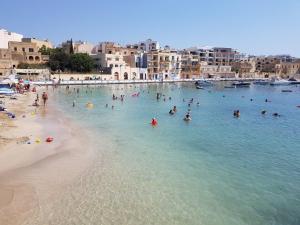 a group of people in the water at a beach at Caris Gem in Birżebbuġa