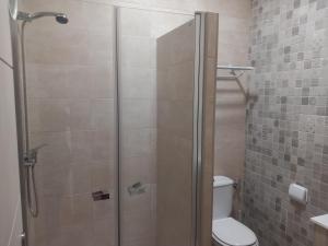 a shower stall in a bathroom with a toilet at Hostal Restaurante La Ilusion in El Palmar