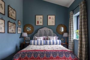 a bedroom with a bed and blue walls at Gilboa House in Malmesbury