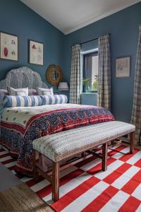 um quarto com uma cama com um banco em Gilboa House em Malmesbury