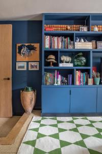 a blue room with a book shelf with books at Gilboa House in Malmesbury