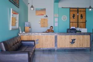 un hombre está sentado en un mostrador en una sala de espera en OceanLife Accommodation Luderitz en Lüderitz