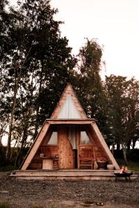 a small cabin with a window and a woman sitting in front at Pattys Farm Barn in Cockerham