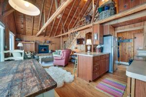 a kitchen and living room in a log cabin at Michigan Cabin Retreat 5 Mi to Sturgeon Bay Beach in Pellston