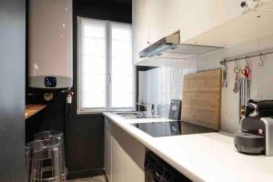 een keuken met een wastafel en een aanrecht bij Appartement cosy cœur de Neuilly-sur-Seine in Neuilly-sur-Seine