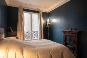 een slaapkamer met een groot bed en een raam bij Appartement cosy cœur de Neuilly-sur-Seine in Neuilly-sur-Seine