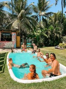 grupa ludzi siedzących w basenie w obiekcie Indiana Kite school and Hostel w mieście Cumbuco