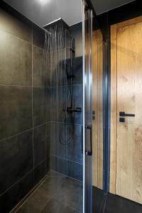 a bathroom with a shower with a glass door at Apartmány Horizont in Loučná pod Klínovcem