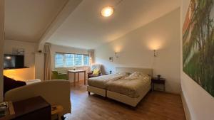1 dormitorio con 1 cama y sala de estar en De Sternhof, en Zeewolde
