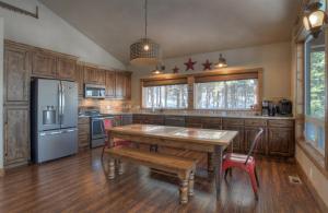 a kitchen with a wooden table and a refrigerator at Crestview Cabin in Pagosa Springs in Pagosa Springs