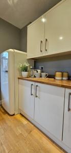a kitchen with white cabinets and a white refrigerator at Place to stay Market Rasen in Market Rasen