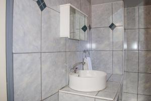een badkamer met een wastafel en een spiegel bij OceanLife Accommodation Luderitz in Lüderitz