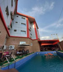 um hotel com piscina em frente a um edifício em Alim Royal Hotel em Jahi