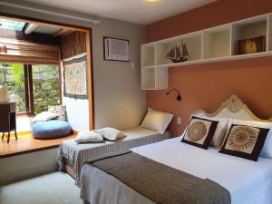 a bedroom with two beds and a window at Pousada Tekoá Indiana in Cachoeiras de Macacu