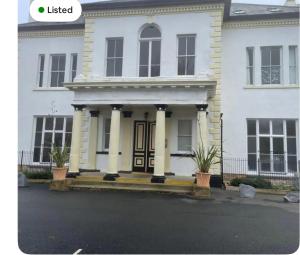 una casa blanca con columnas y una puerta principal en 1 Hatton house 2 bedroom 2 bathroom spacious basement flat, en Newark-on-Trent