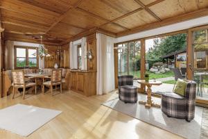 ein großes Wohnzimmer mit Tisch und Stühlen in der Unterkunft Bayern Chalets bei Salzburg und Berchtesgaden mit Whirlpool und Sauna in Ainring