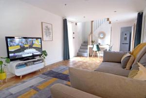 sala de estar con sofá y TV de pantalla plana en Beautiful barn conversion with easy access to York, en Selby