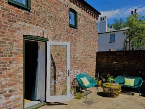 a brick building with two chairs and a table at Beautiful barn conversion with easy access to York in Selby