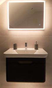 a bathroom with a white sink and a mirror at Beautiful barn conversion with easy access to York in Selby +10 photos