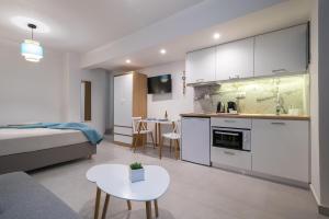 a kitchen and living room with a bed and a table at ALMIRA Studios Limnos 3 in Mirina