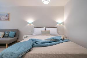 a bedroom with a bed and a couch and lights at ALMIRA Studios Limnos 3 in Mirina