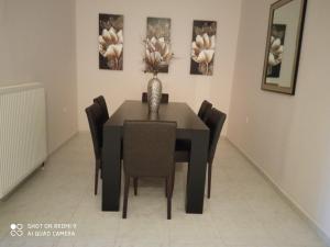 a dining room table with black chairs and a vase on it at serres center in Serres