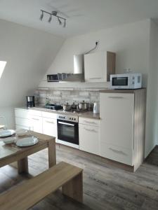 a kitchen with white appliances and a wooden table at Ferienwohnung Liane in Federow