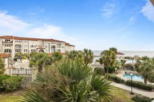 a view of a resort with a pool and palm trees at Villa Capriani Condo with Direct Beach Access! in North Topsail Beach