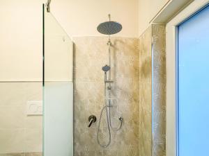 La salle de bains est pourvue d'une douche et d'une porte en verre. dans l'établissement Brain Harmony Pagani, à Pagani