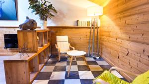 a room with wooden walls and a table and a chair at Le Grenier 1821 - Mini chalet - Centre village - AravisTour in Saint-Jean-de-Sixt