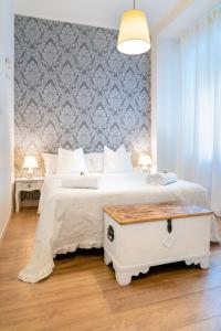 una camera da letto con un grande letto bianco e un muro di Residenza Porta Palio a Verona