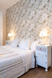 una camera con un letto con una parete floreale di Residenza Porta Palio a Verona