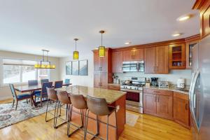 a kitchen with wooden cabinets and a table with bar stools at 61 East Field Road in Jackson
