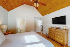 a bedroom with a large bed and a flat screen tv at 61 East Field Road in Jackson