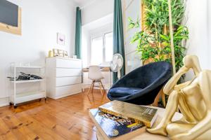 a living room with a chair and a book on a table at April Square by Lisbon with Sintra in Amadora