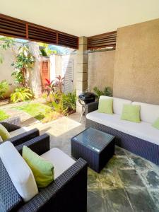 a patio with couches and chairs and a table at Tropical Villa - 3 Bedrooms in the heart of Grand-Baie in Grand Baie