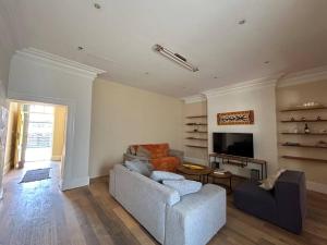 a living room with a couch and a tv at The Yellow House in Cape Town