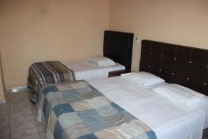 two beds in a hotel room with two bedsvisor at CV Apart in Resistencia