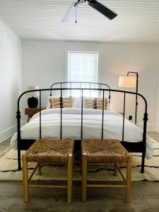 a bedroom with a bed with a black frame and two chairs at Cramerton/Belmont's Modern and perfect retreat in Cramerton