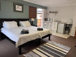 Un dormitorio con una cama con dos pares de zapatos. en Lovely Garden Studio1 - 10 minute walk from beach, en Ciudad del Cabo