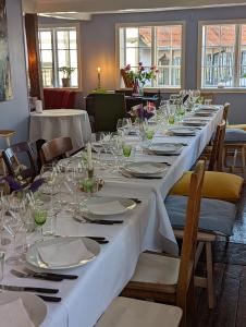 een lange tafel met borden en glazen erop bij Pensionat Næsgaarden in Allinge