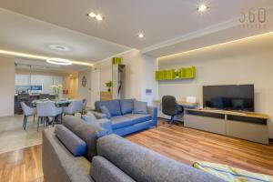 un salon avec des canapés bleus et une télévision dans l'établissement Luxury 3BR home in St Julians with private terrace by 360 Estates, à Taʼ Ċikkun