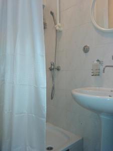 y baño con cortina de ducha y lavamanos. en Guesthouse NO.27, en Mostar