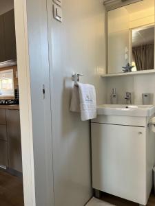 a white bathroom with a sink and a mirror at Mobile Home La Vida in Biograd na Moru